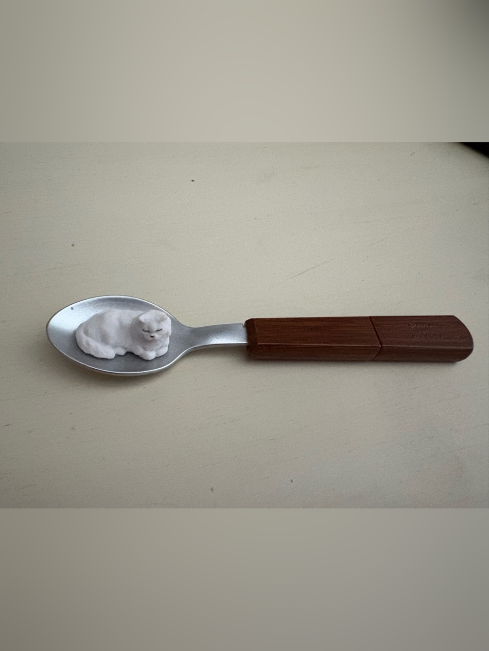 Japanese Collectable Toy. White cat on wooden spoon.